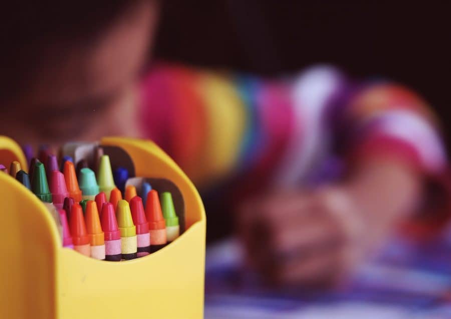 child with crayons moving overseas